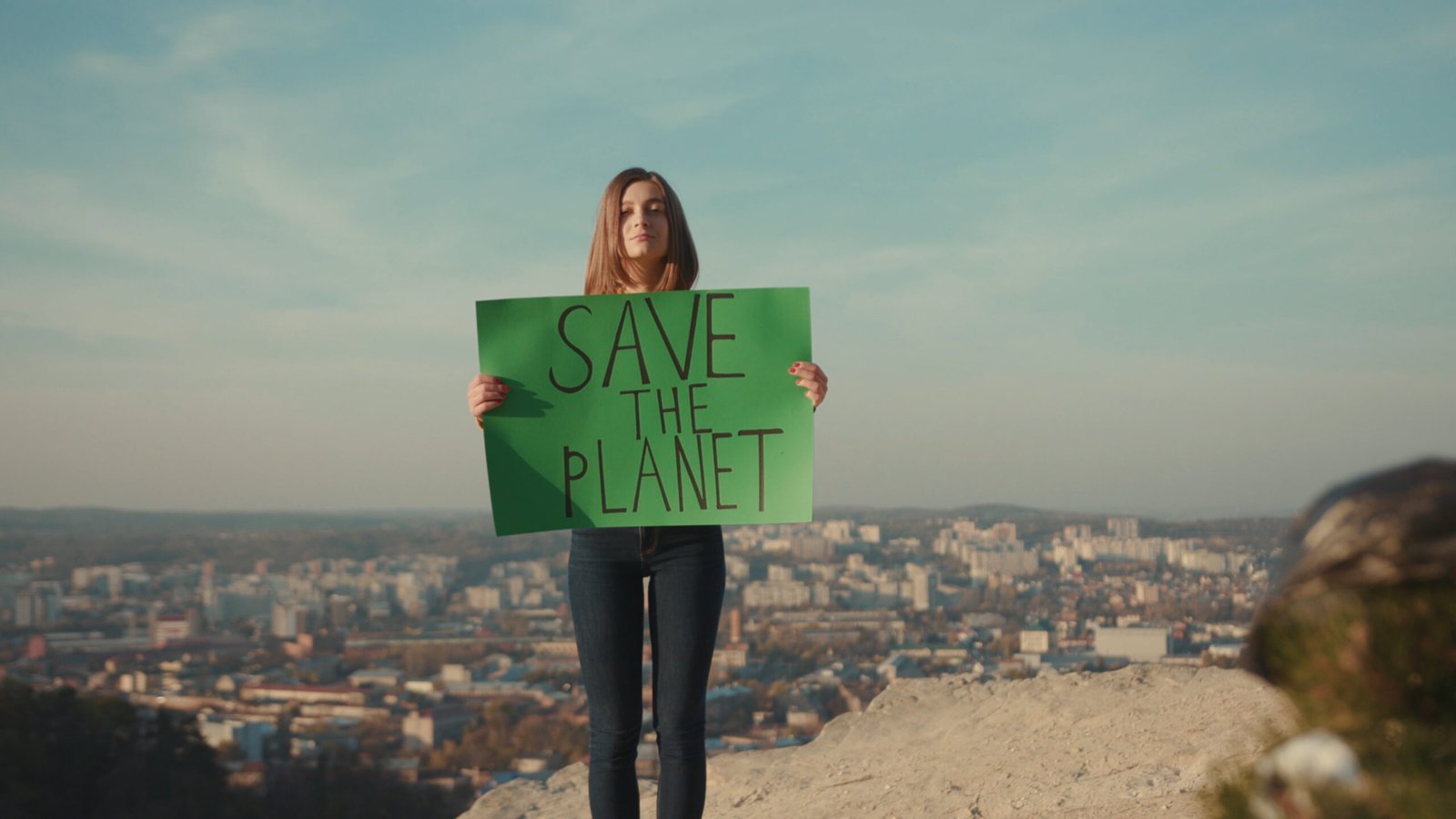 Young woman activist holding encouraging green poster Save the Planet standing around plastic bag background beautiful view nature environmental community earth eco outdoor recycle trash waste